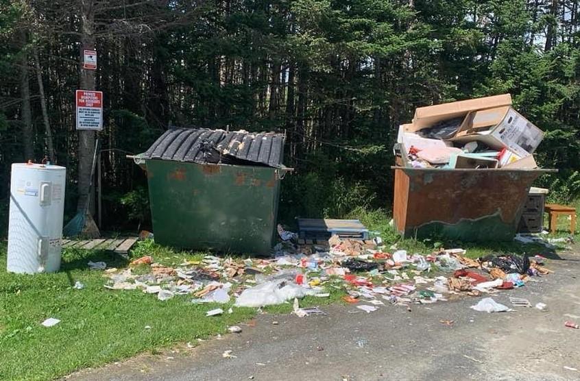 A dumpsters and a sign

Description automatically generated